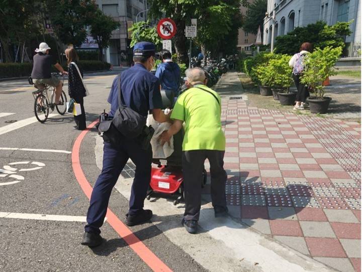 捷運警察合力推著電動輪椅,護送失智長者返家途中,沿途不忘關心安全,溫情畫面令人動容。(圖/記者林家嘉翻攝)