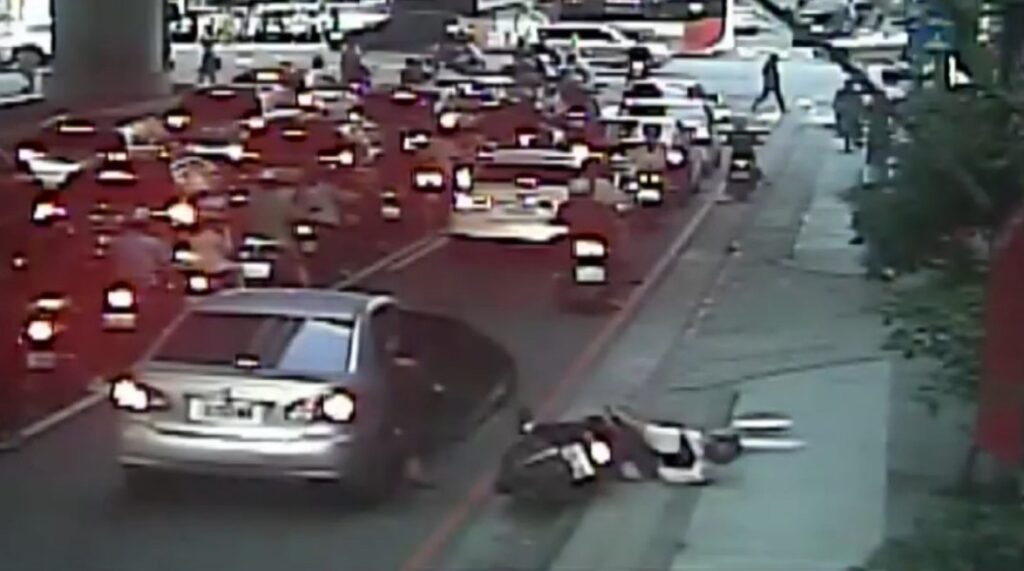 後方機車遭突開車門影響重心失控，人車倒地，所幸騎士僅受輕傷。（圖／記者林家嘉翻攝）