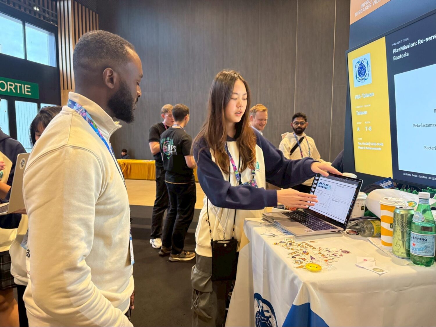 HIA學生向國際與會者介紹抗藥性研究專案，分享團隊設計的基因溝通系統與社會實踐行動，讓世界看見臺灣青年科研能量。（圖/記者張家燁翻攝）