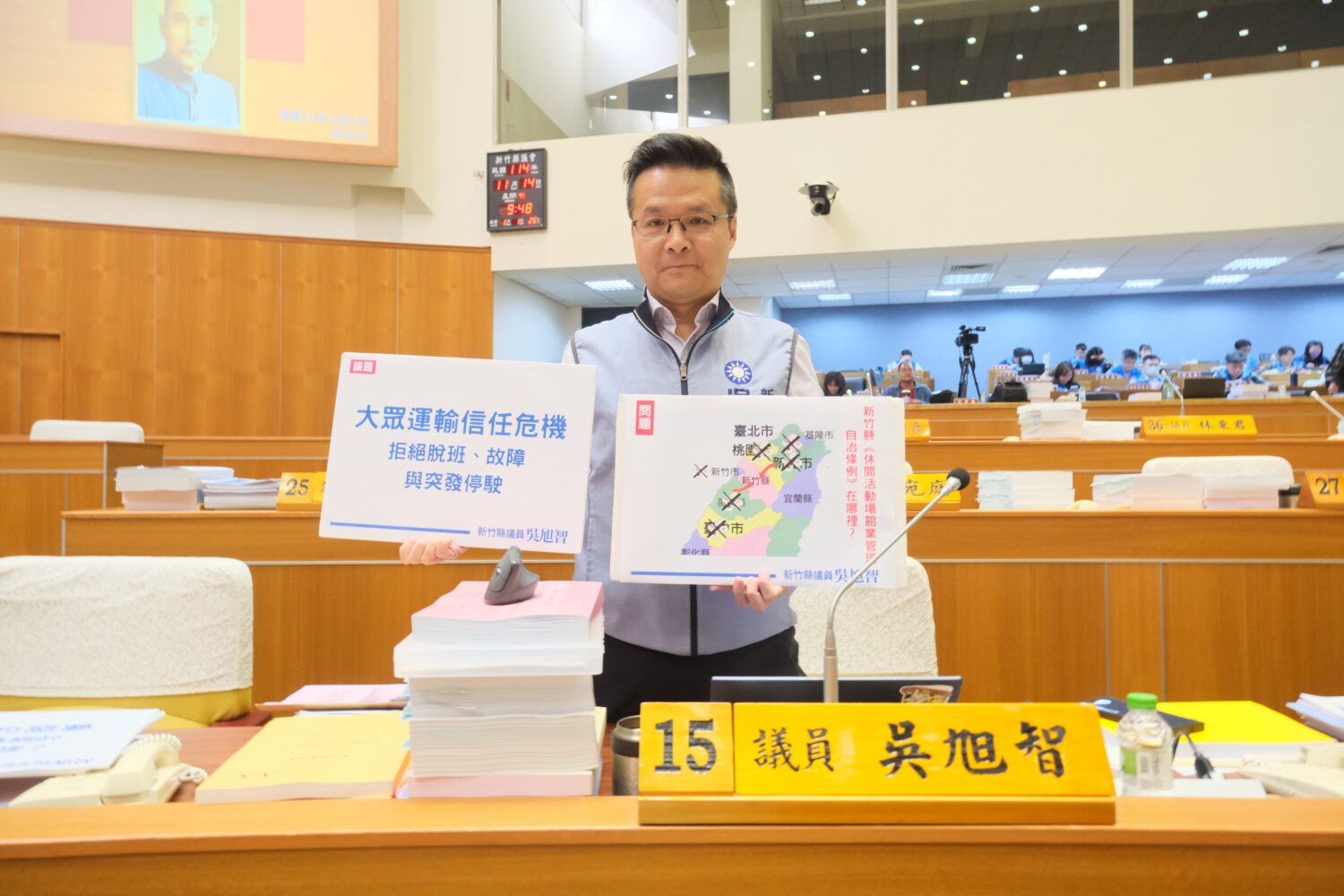 吳旭智議員於會場展示圖卡,指出大眾運輸脫班、校園壅塞與休閒娛樂場所管理問題迫切需改善。(圖/記者林照東翻攝)