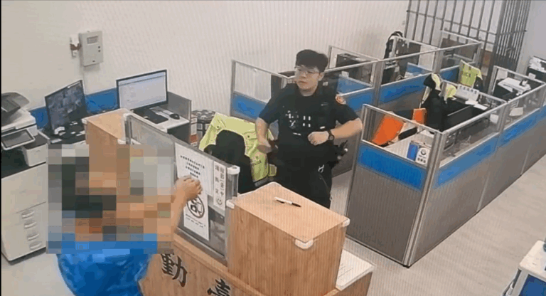 李男涉嫌殺害56歲妻子羅女,並於17日前往內壢派出所自首。到達警局後他主動將雙手靠攏、示意警員上銬。(記者翻攝)