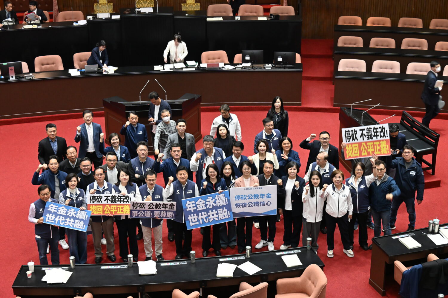 立法院三讀通過公務人員退休資遺撫卹法第三十七條修正案以及公立學校教職員退休資遺撫卹法第三十七條修正案,國民黨團舉牌慶祝。(圖/黃仁國會辦公室)