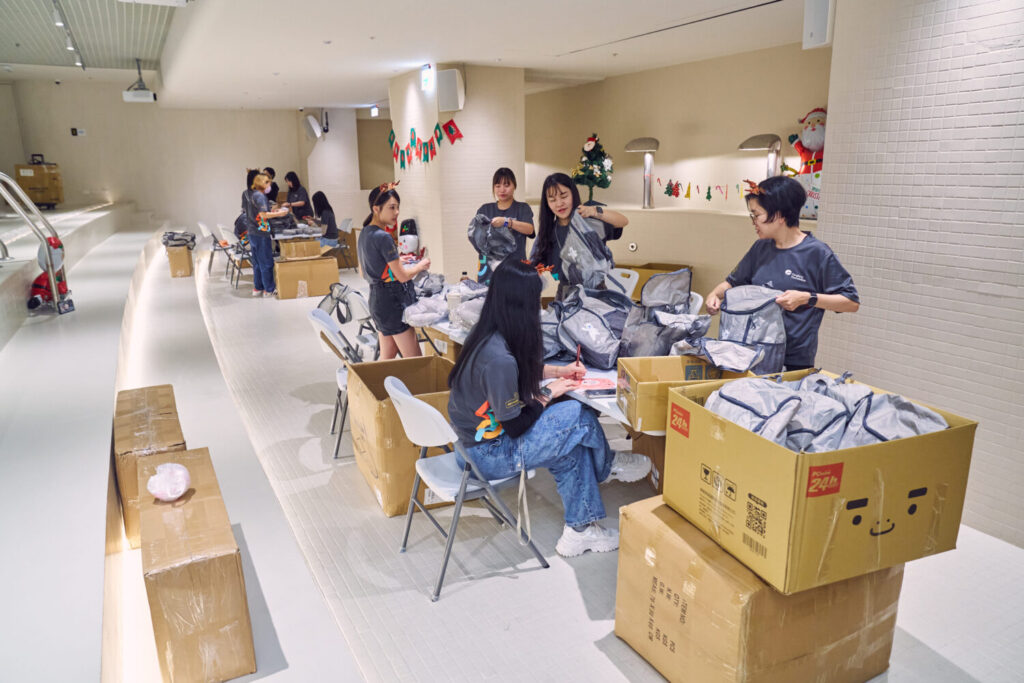 遠雄志工們以流水線作業方式，分工包裝耶誕禮物。（圖／遠雄文教公益基金會提供)