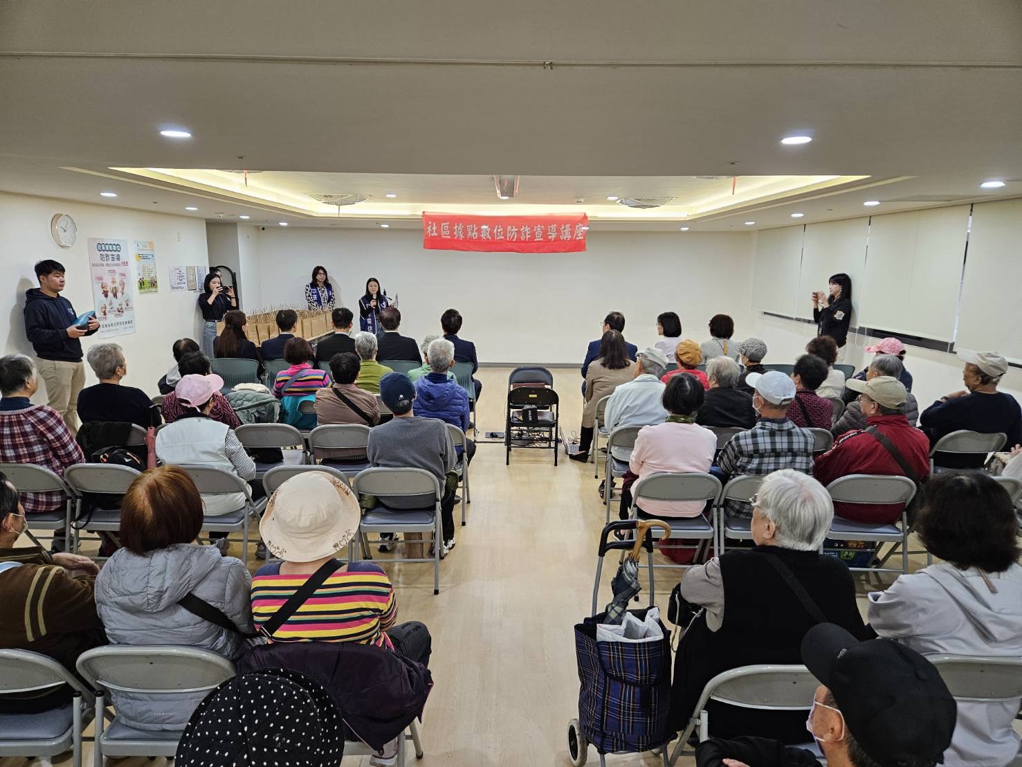活動現場吸引近百位長者，仔細聆聽「數位防詐」宣導重點。(圖/紅心字會 提供)