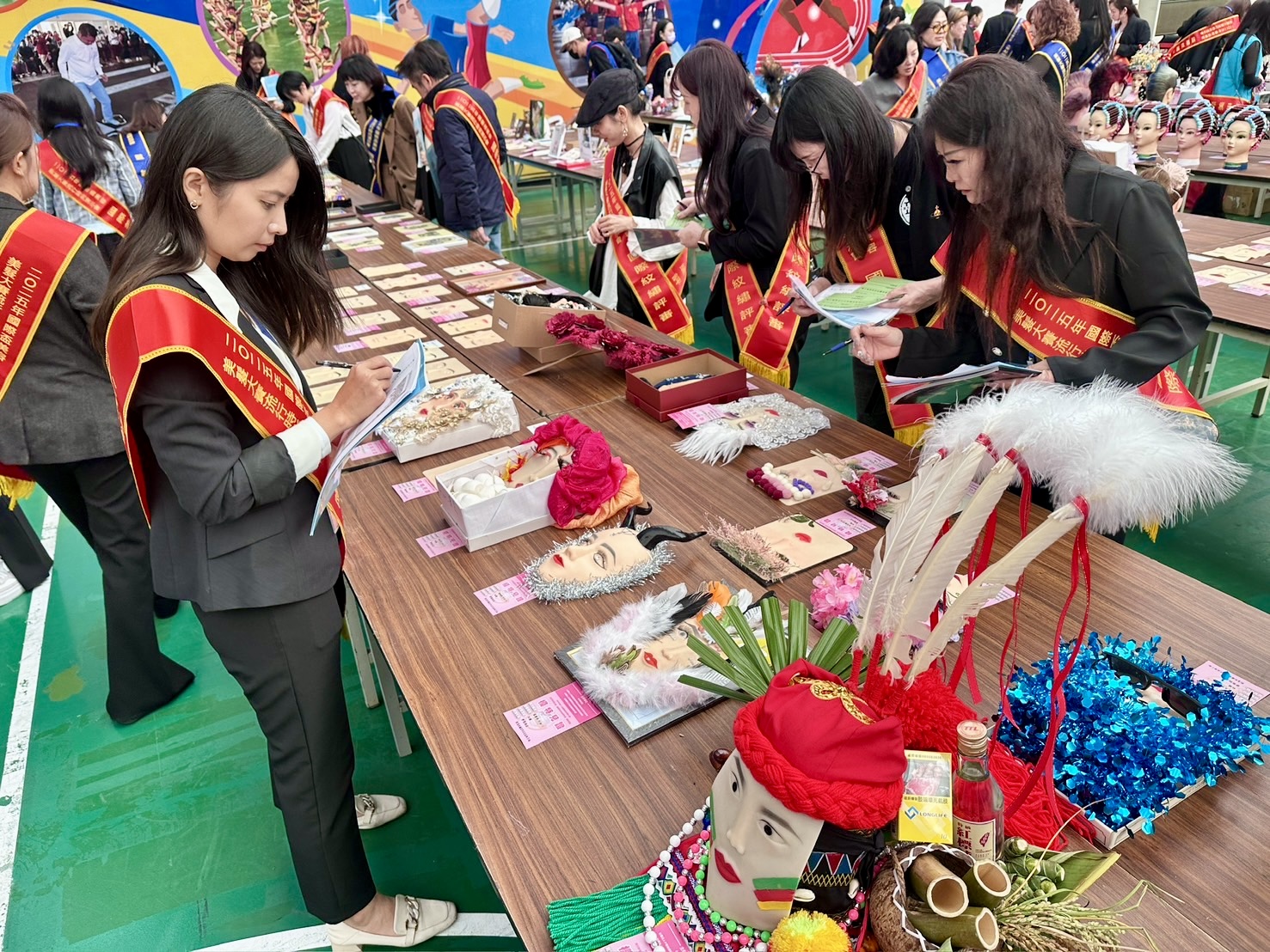 國際盃美容美髮大賽競賽現場，評審團仔細檢視選手作品細節，從造型結構、創意巧思到整體完成度逐一評分，展現賽事專業與嚴謹。（圖／記者林照東攝）