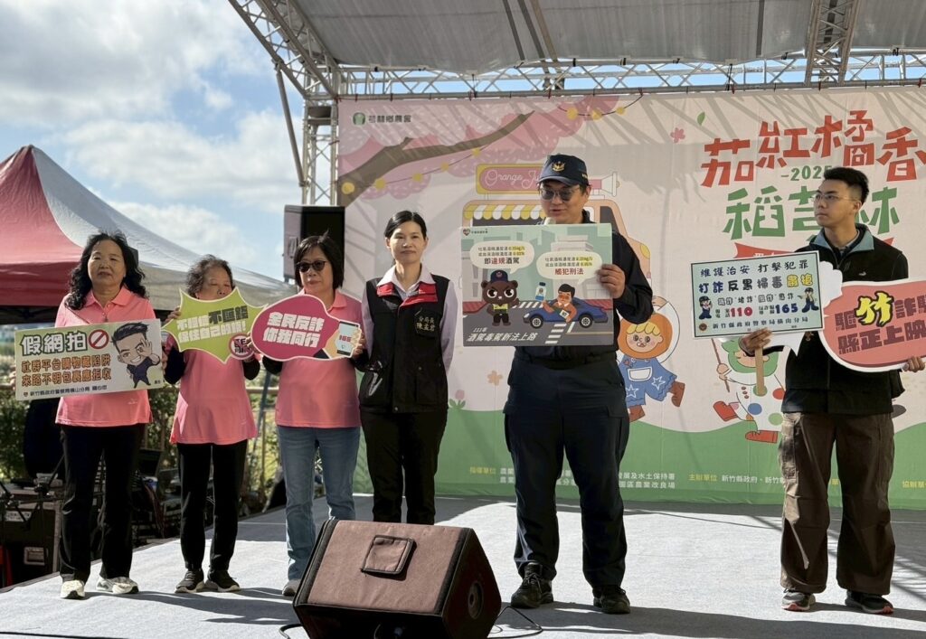 橫山分局結合芎林農會於「茄紅橘香稻芎林番茄產業文化活動」進行反詐與交通安全宣導，分局長陳孟君與同仁手持識詐、反毒駕等宣導標語，透過互動方式提醒民眾提高警覺，共同守護社區安全。（圖/記者張家燁翻攝）