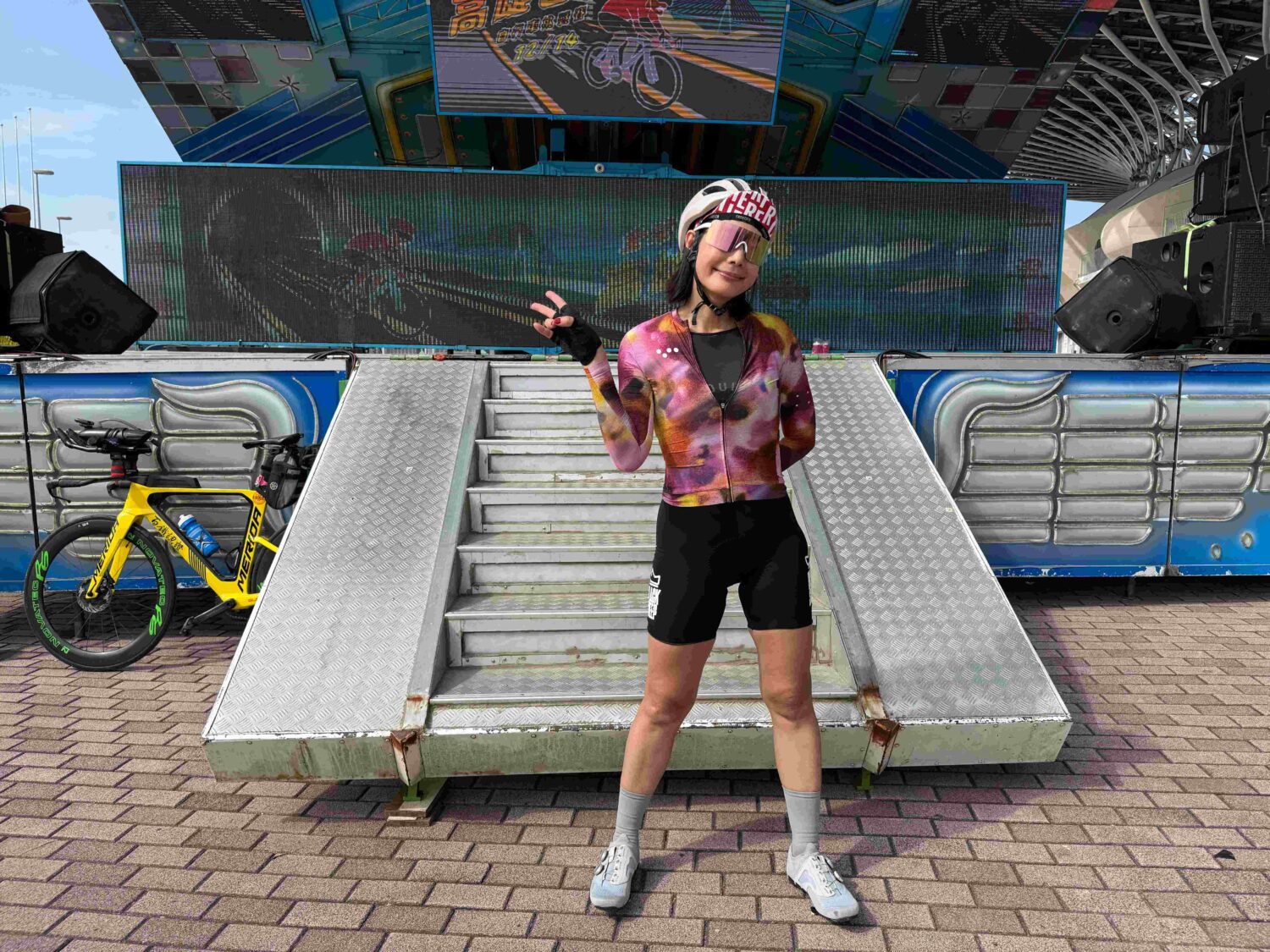 藝人丁寧於高雄百K自行車挑戰賽完賽後於終點舞台前合影留念,成功完成人生首場百公里耐力騎乘,展現跨界挑戰的毅力與自信。(圖/記者張家燁翻攝)