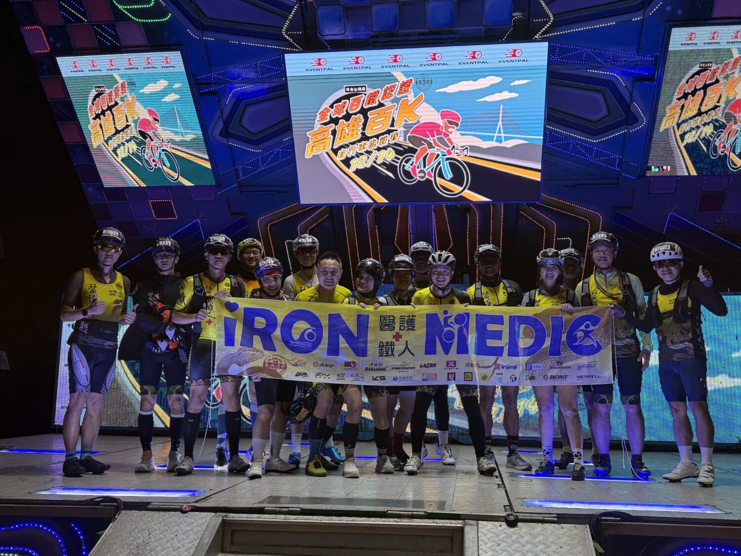 醫護鐵人團隊完賽後於終點舞台合影,象徵運動結合公益與專業醫療支援,為「全球百鐵認證高雄自行車百K挑戰賽」增添溫暖力量。(圖/記者張家燁翻攝)