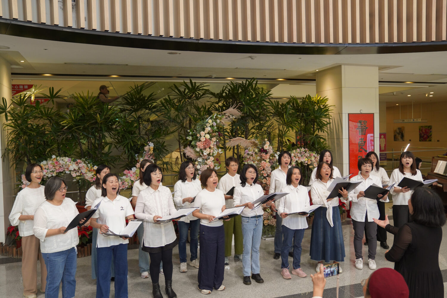 樂樂合唱團於中國醫藥大學新竹附設醫院大廳溫馨獻唱，多首合唱曲在指揮帶領下悠揚響起，為醫護人員、病患及家屬帶來療癒與祝福，現場洋溢聖誕感恩氛圍。（圖/記者張家燁翻攝）