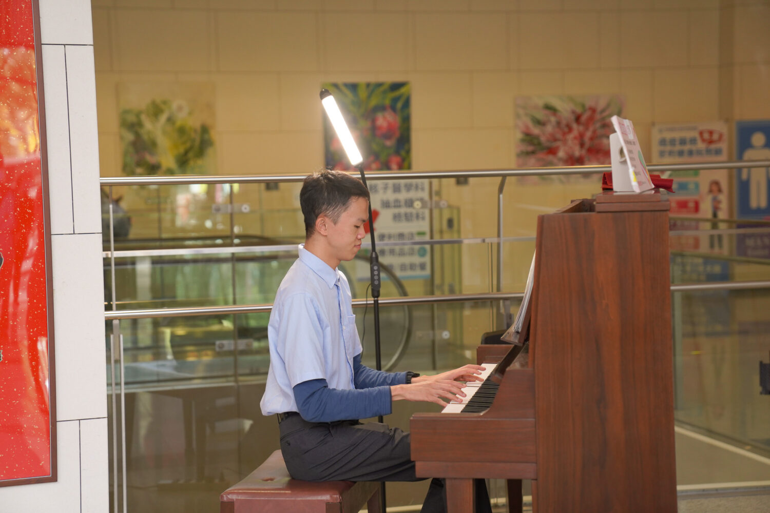 慢飛兒庇護工場音樂才子卓新元於醫院大廳彈奏鋼琴，以〈夢中的婚禮〉、〈那些年〉等動人旋律傳遞希望與和平，感動在場聆聽的民眾與醫療團隊。（圖/記者張家燁翻攝）