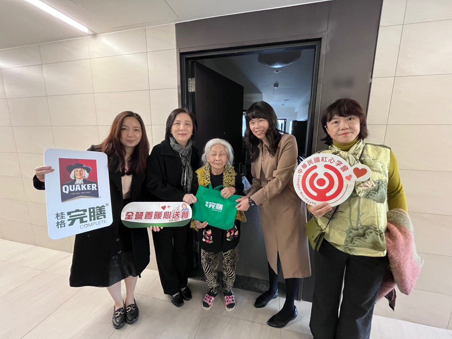 左起-產品組經理楊久盈、紅心字會李顯文秘書長、社宅91歲獨居余奶奶、資深行銷經理潘雨青、紅心字會許雅青副秘書長，將全營養軟質餐暖心送到府！(圖/紅心字會 提供)