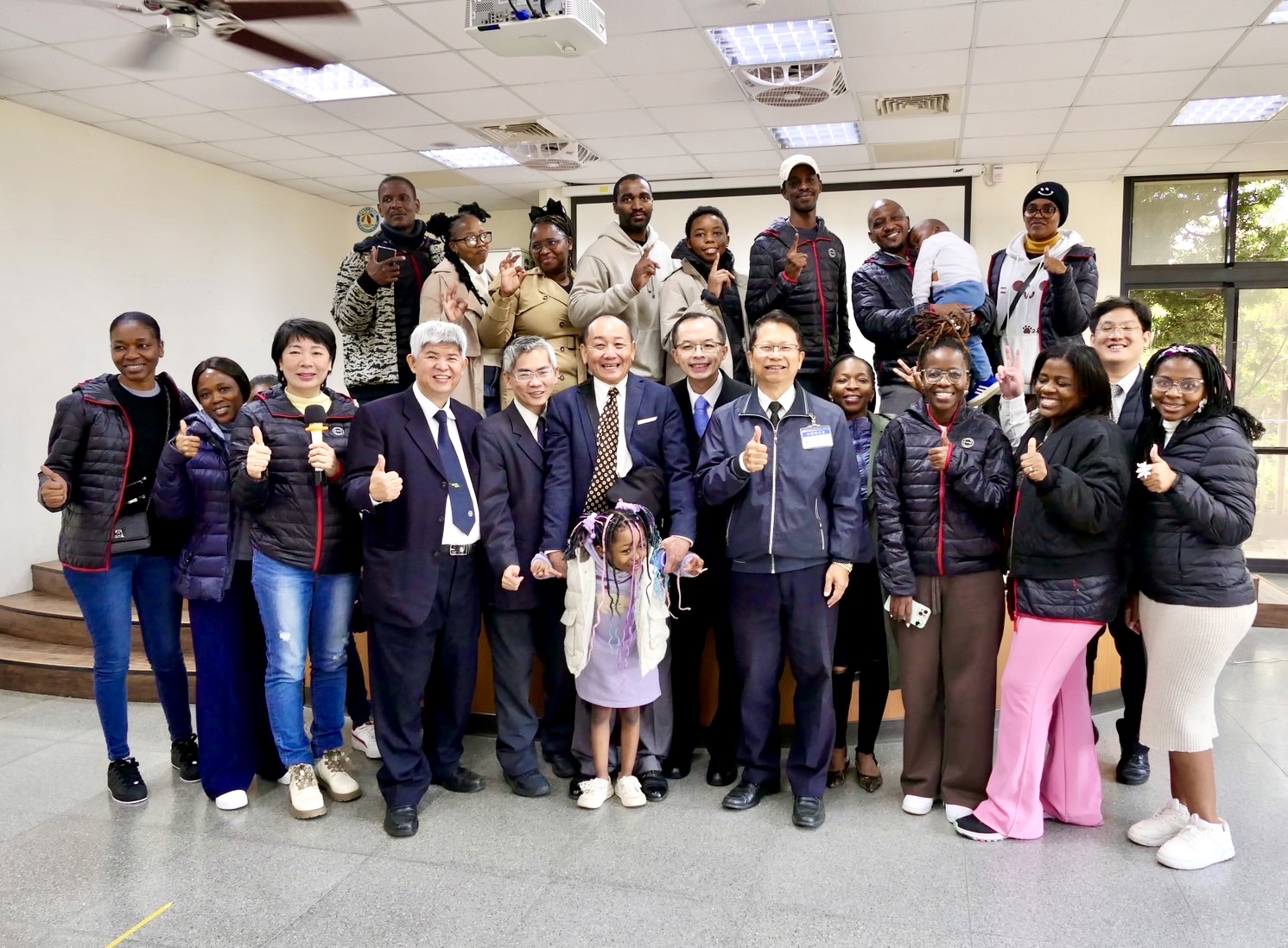 美仁食品有限公司董事長陳美仁與來自史瓦帝尼王國的青年朋友合影留念，活動中捐贈羽絨外套，協助友邦朋友適應台灣冬季濕冷氣候。（圖／記者林照東攝）