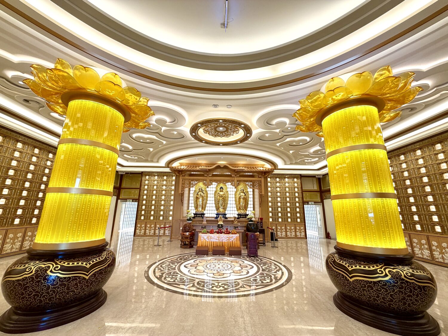 雙峰寶塔大殿內部一景，殿內供奉西方三聖佛像，整體空間莊嚴肅穆，搭配蓮花造型立柱與納骨櫃位設計，展現生命禮儀設施的人文與宗教氛圍。（圖／記者林照東攝）