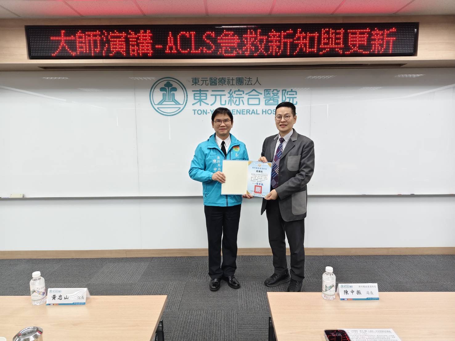 新竹縣政府消防局長陳中振（左）代表致贈感謝狀予雲林臺大分院副院長江文莒醫師（右），感謝其蒞臨主講「大師講堂－新竹EMS大補帖」，分享 2025 年最新版 ACLS 急救新知，協助提升竹竹苗地區院前救護專業量能。（圖/記者張家燁翻攝）