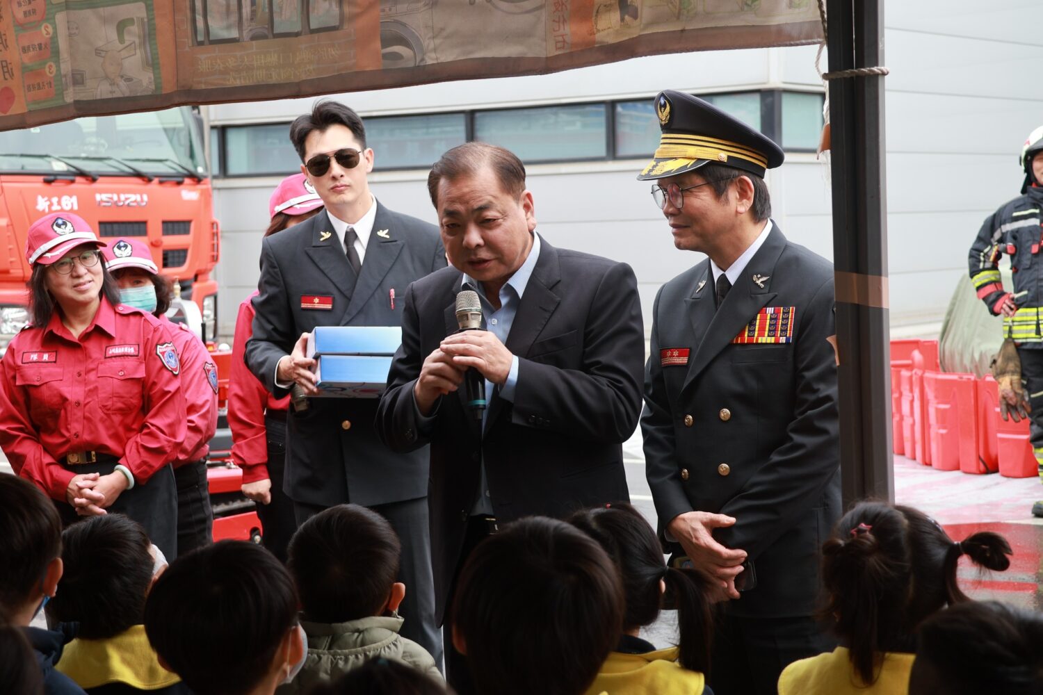 新竹縣政府消防局辦理大型工廠救災救護勤務演習，副縣長陳見賢於現場向參與活動之幼兒園學童進行防災安全宣導，透過近距離互動，向下扎根推廣防火、防災與逃生觀念。（圖/記者張家燁翻攝）