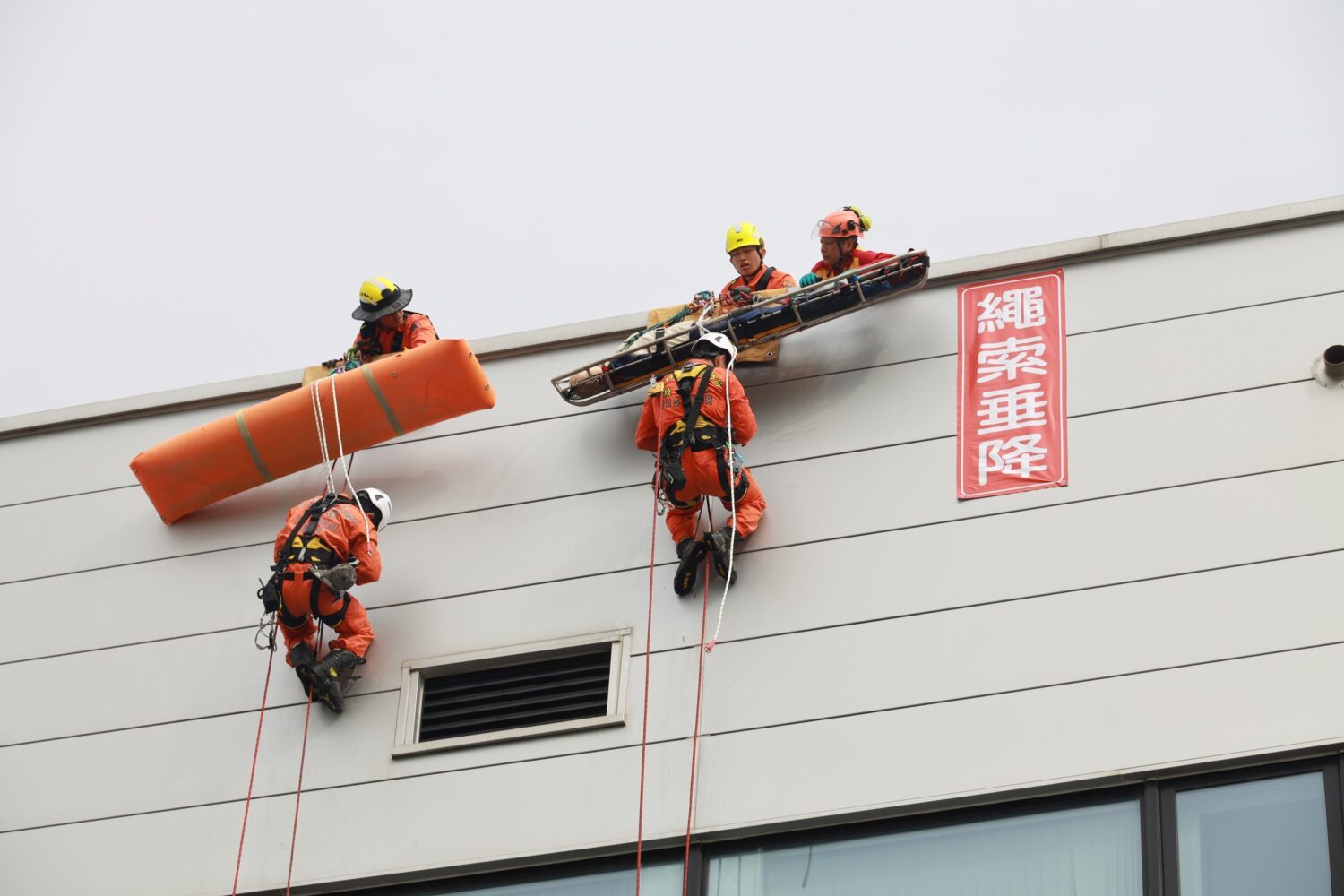 消防人員實施高空繩索垂降救援演練，模擬高樓受困人員救助情境，展現專業繩索技術與垂直救災能力，提升複合型災害應變效能。（圖/記者張家燁翻攝）