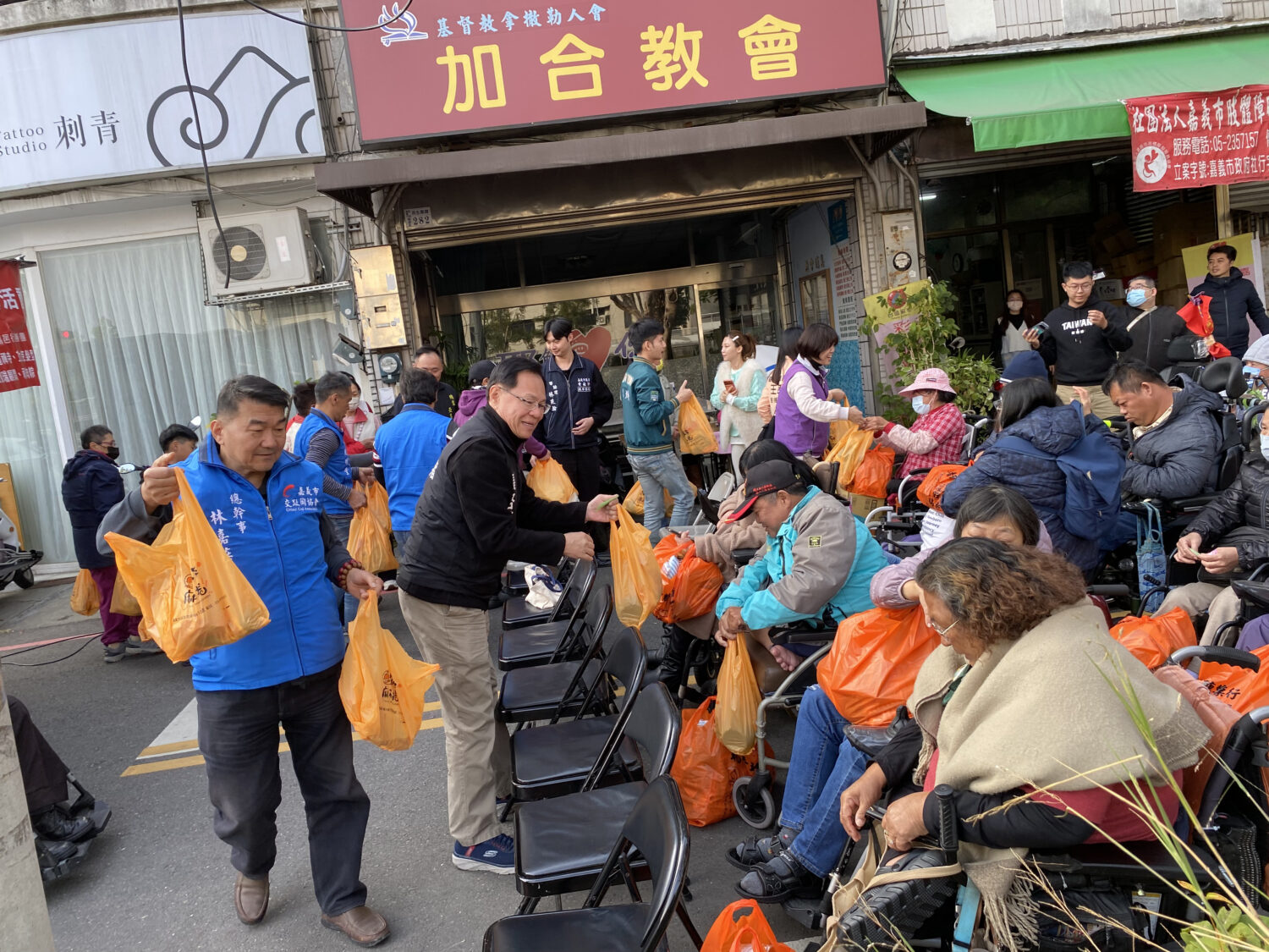 張啓楷親自下場將愛心物資分送到現場弱勢市民手中。(記者 包克明攝)