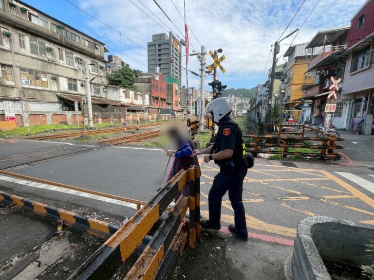 警方護著老婦人過平交道。（記者李健興翻攝）