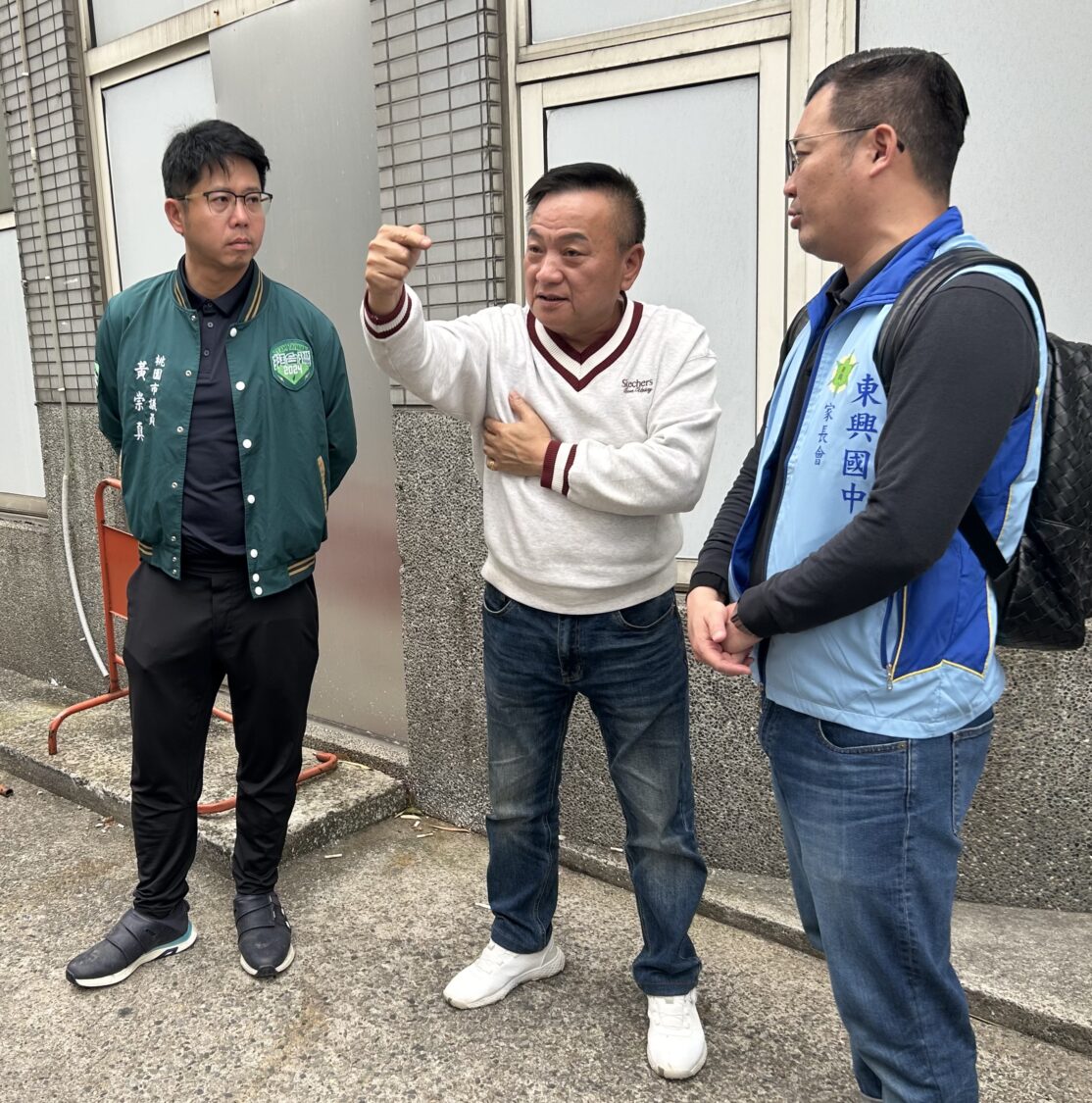 明德里里長陳朝福（中）今（26）日同市議員黃崇真（左）與信義國小榮譽家長會長陳信州（右）等，前往中壢區信義國小外的昆明街3號進行會勘，展開增設人行道的可能討論。（記者翻攝）