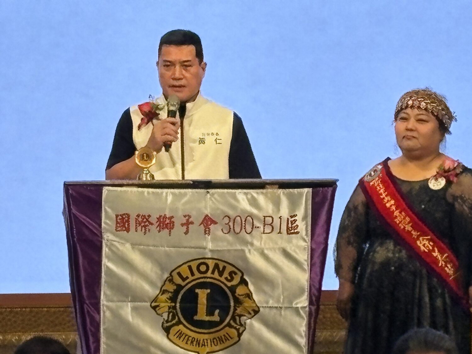 國民黨平地原住民立委黃仁致詞，右為擁有排灣族血統的新北市中央獅子會長徐美芝。(圖／黃仁國會辦公室)