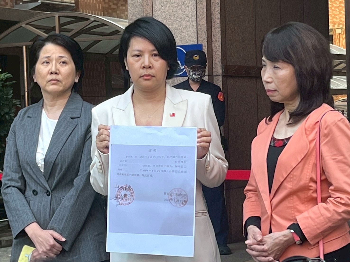 立法委員李貞秀於行政院中央聯合辦公大樓前召開記者會，手持相關證明文件，說明國籍與戶籍程序始末，強調身分合法。（圖／記者林照東攝）