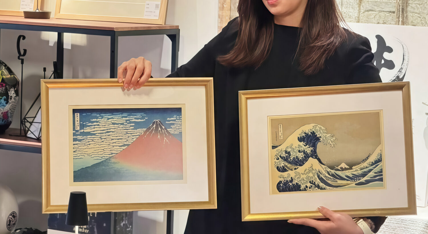 李仕璽藏家經紀人Kelly Lin 於展場手持浮世繪版畫展示著名浮世繪大師葛飾北齋《神奈川沖浪裏》與《凱風快晴》作品。 ((圖/攝於榕錦時光Quest Taipei listening bar / 藏家李仕璽提供圖片)