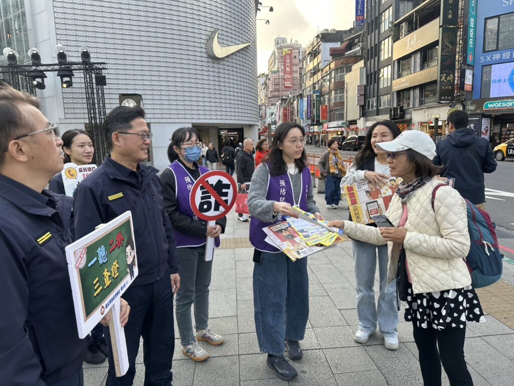 萬華分局員警向現場民眾進行防詐騙宣導。（圖／記者 趙靜姸翻攝）