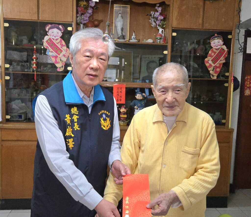 退警總會黃啟澤（左）總會長致上警政署張署長的百歲人瑞年節金給繆潤之（右）會員。（圖 ／耿繼文提供）