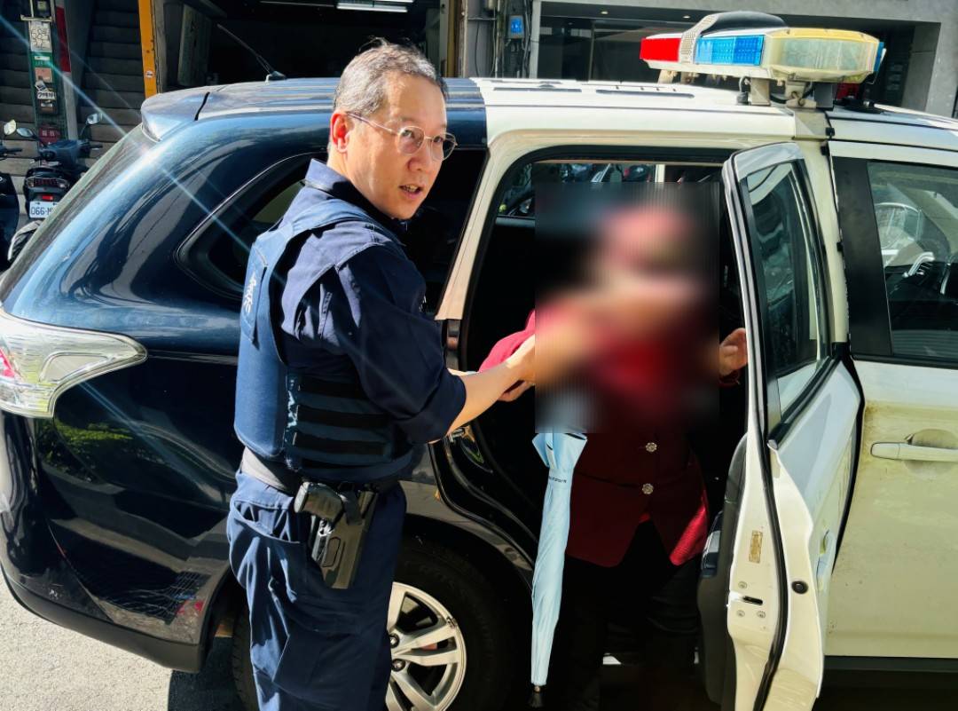 員警攙扶老婦上車。(圖/記者戴昱弘 翻攝)