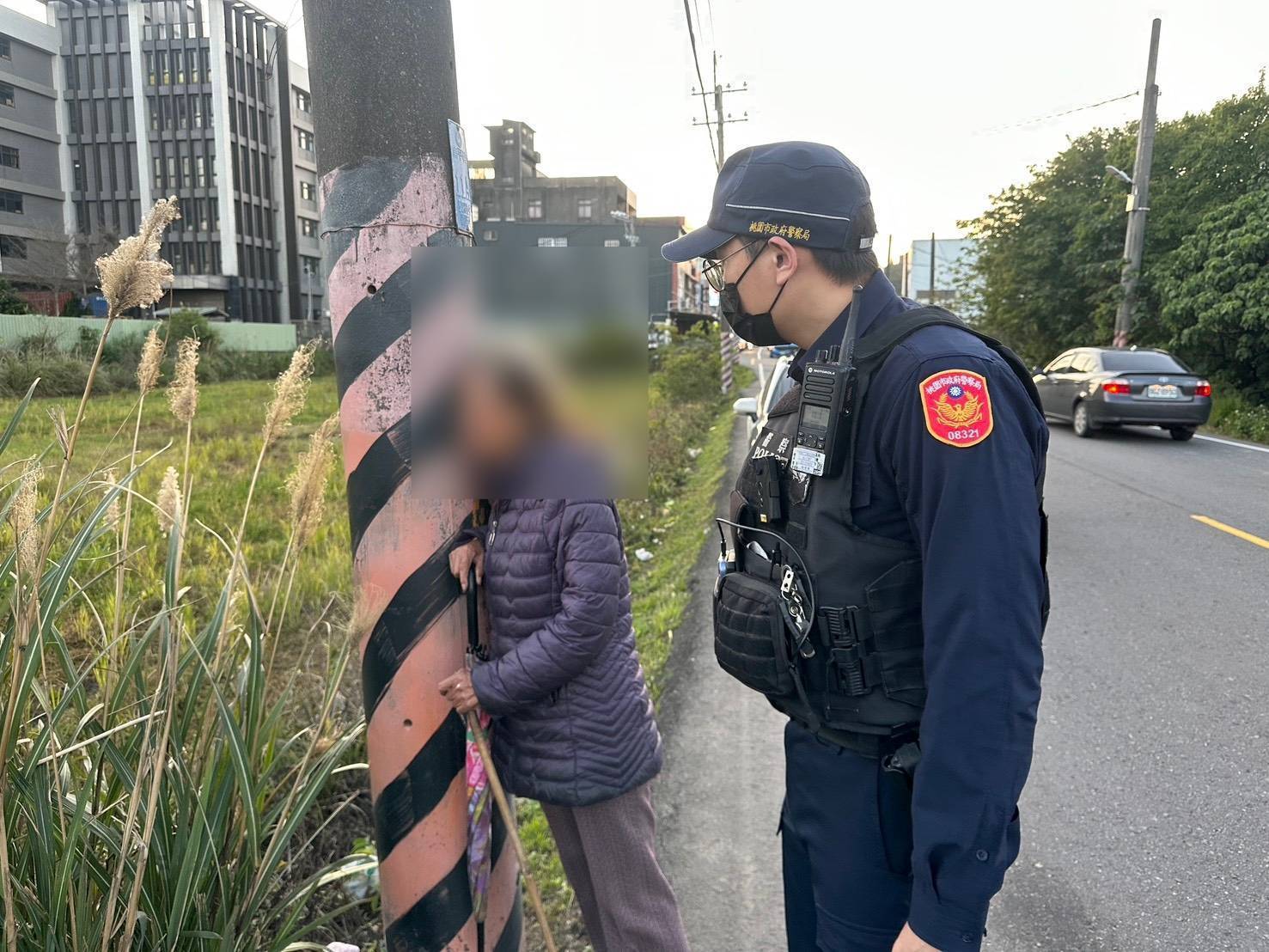 78歲吳姓老婦人(左)趁家人不注意獨自外出,步行至平鎮區南平路二段時,被龐大車流嚇到只能抱著電桿,所幸平鎮派出所員警發現,才幫助其成功返家。(記者翻攝)