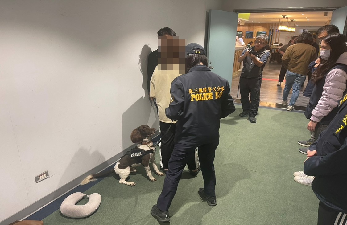 警犬聞到黃女身藏毒品後,立即坐下示警。(記者徐煜勝翻攝)