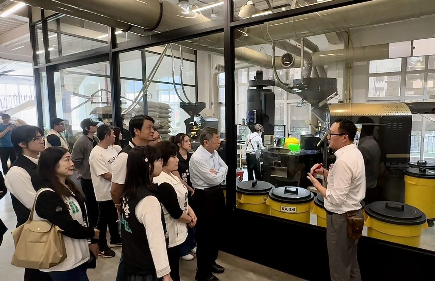 赫曼咖啡王進忠總經理導覽工廠烘焙設備與製程流程,說明導入光儲整合系統後的節能成果。(圖/記者林照東翻攝)