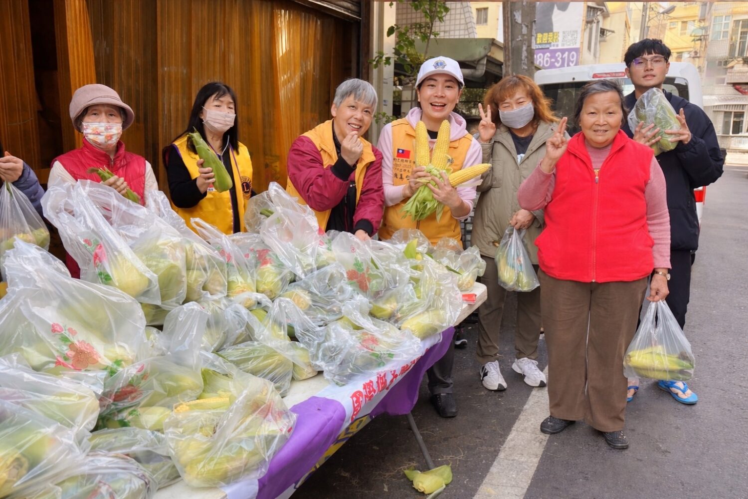 現場準備大量新鮮玉米發送給居民,陳美仁董事長與志工團隊合力分送,象徵豐收與希望,為新學期注入正能量。(圖/記者林照東翻攝)