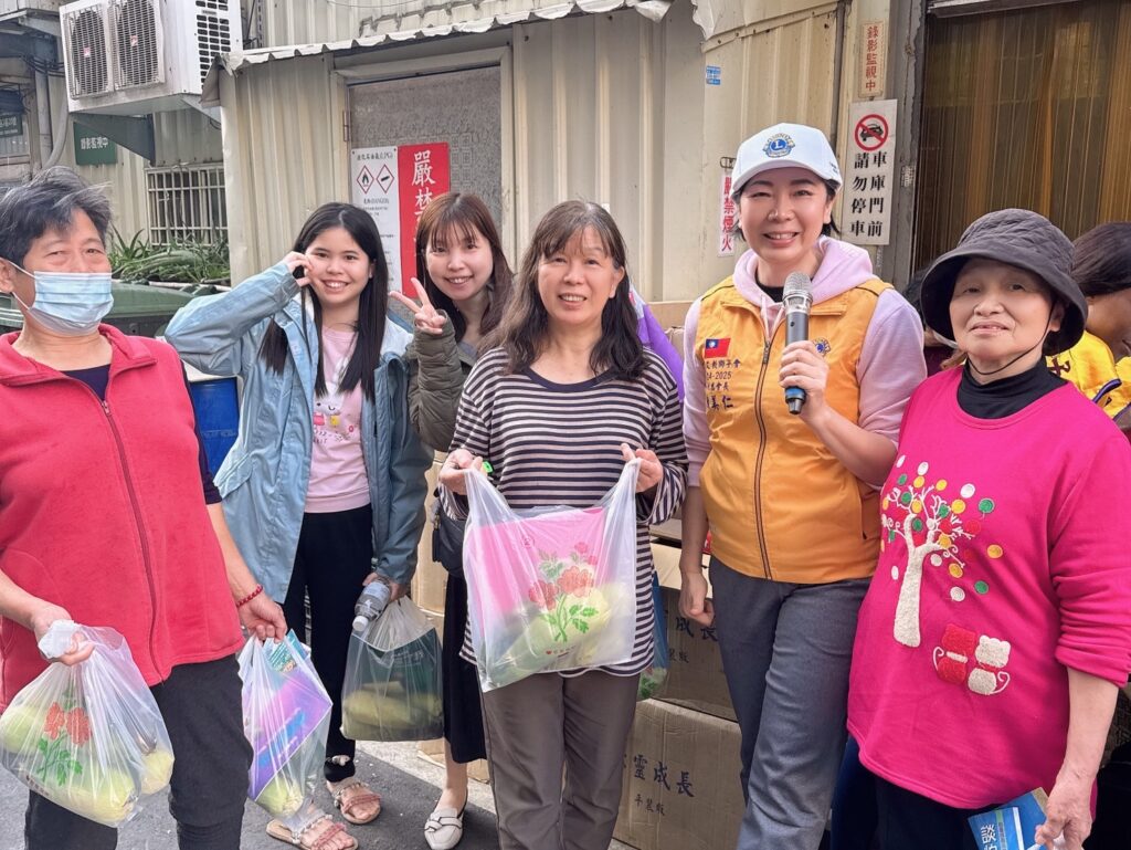 活動吸引多位在地居民參與，民眾手持玉米與物資合影留念，現場氣氛溫馨熱絡，展現社區凝聚力。（圖／記者林照東翻攝）