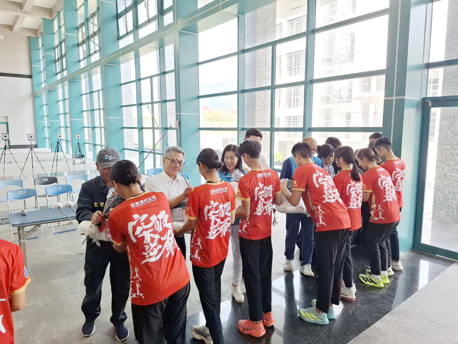 王春梅等人將符合國際賽事標準的西洋劍服裝與設備給台東體中現代五項隊員。(圖/記者翻攝)