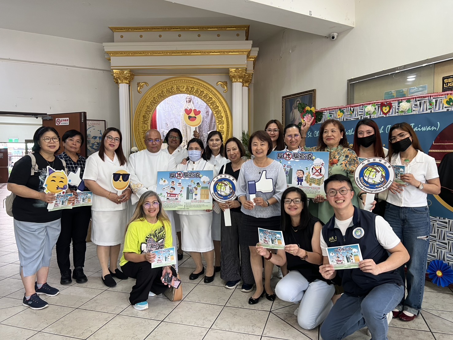 移民署臺北市服務站主任蘇慧雯(前排右三)、聖多福天主堂神父馬萬程(左四)與教友及移工們齊心反詐。(圖/記者 趙靜姸翻攝)