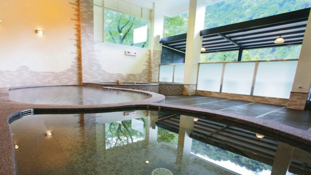 體驗烏來著名的「美人湯」，碳酸氫鈉泉質清澈透明，洗後肌膚觸感滑嫩，讓身心在大自然的溫潤包覆中重拾輕盈與美麗。（圖／堤畔溫泉民宿-新北市政府提供）