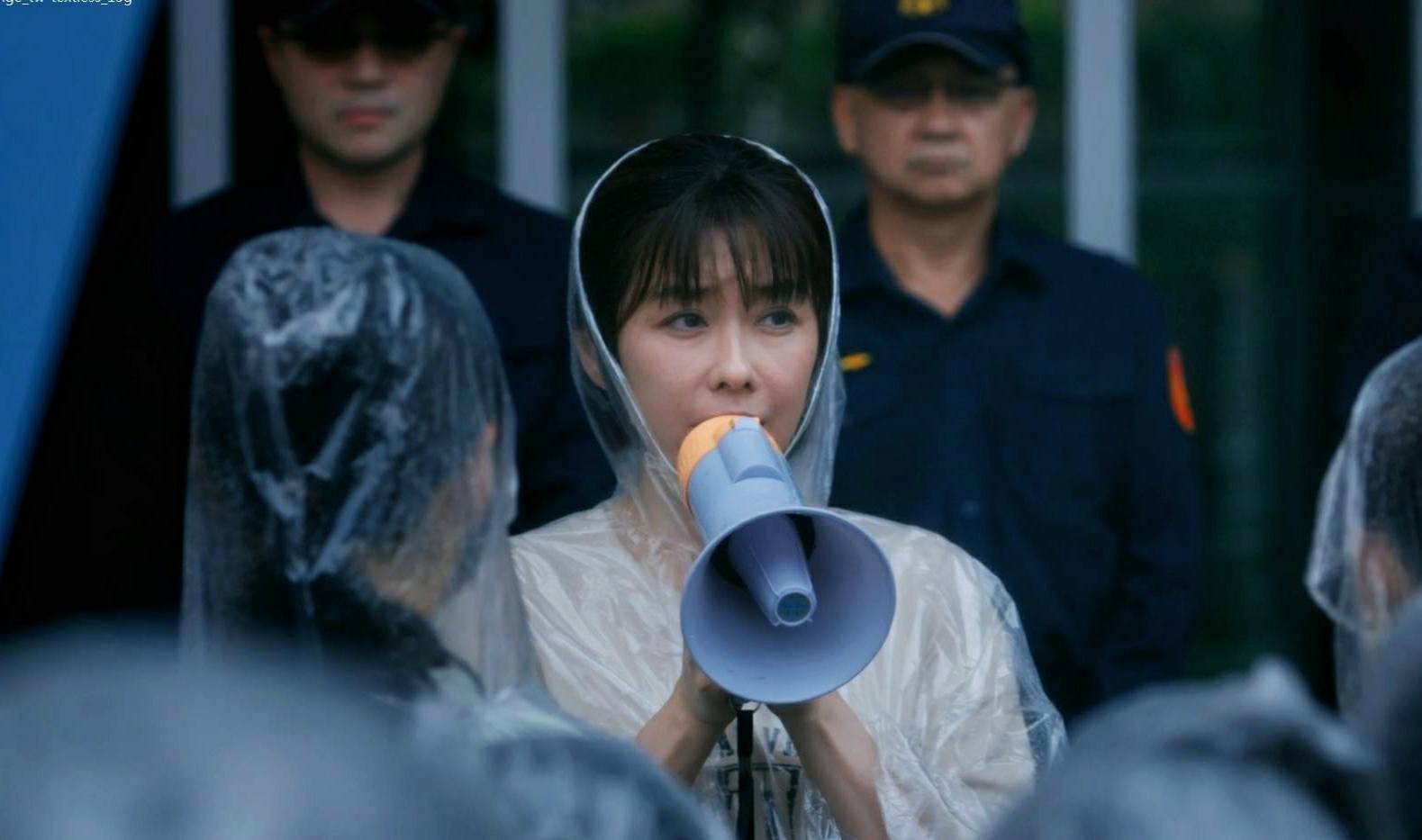 李維維手持大聲公，在警察人牆前神情堅毅地發表訴求 。