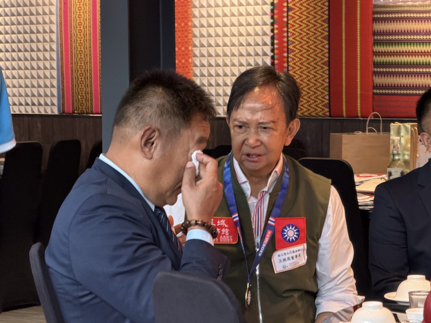 
泰北義民文史館主任委員王紹章（左）觀看由異域故事館創辦人董事長王根深（右）製作的紀錄影片時，想起泰北孤軍故事，忍不住紅了眼眶。(圖/泰北義民文史館 提供)