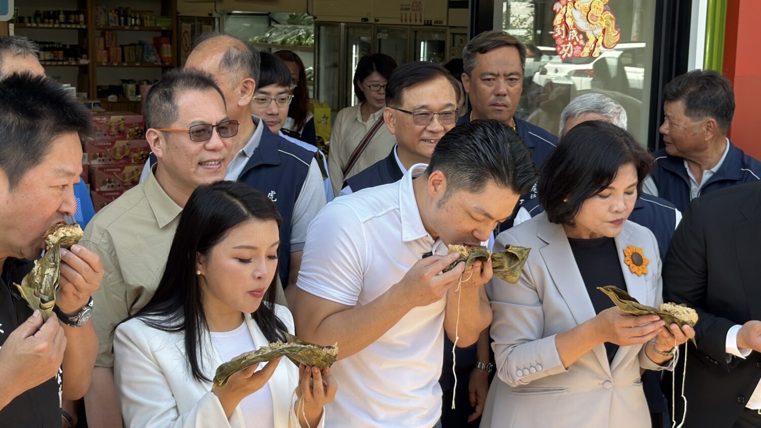 蔣萬安（中）、張麗善（右）現場品嚐虎尾產銷履歷花生粽，大讚花生香氣濃郁、口感紮實。（圖／記者 張泓笙翻攝）