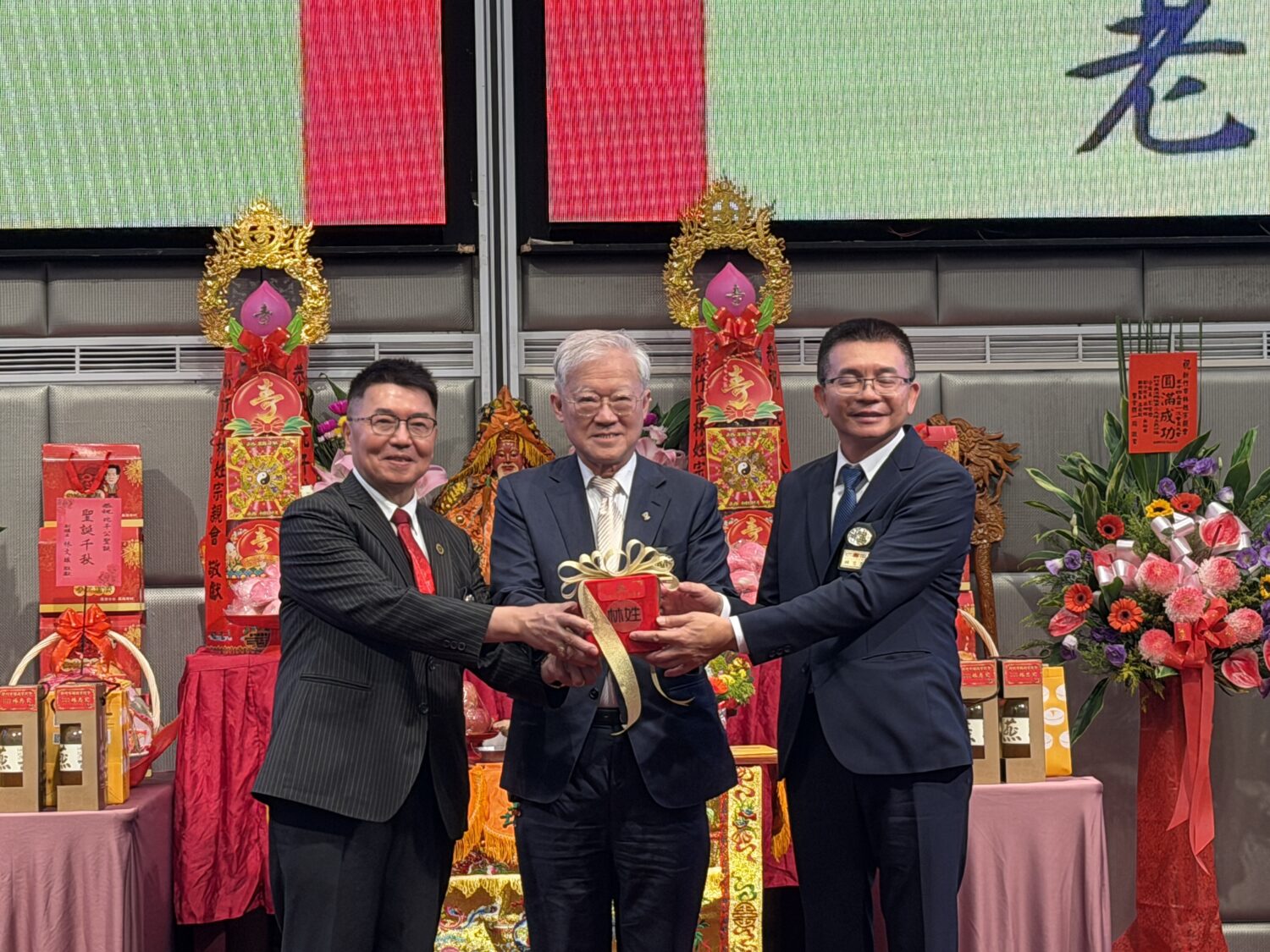第十四屆理事長交接儀式，由中華民國林姓宗親總會林晉章總會長監交（中），現任理事長林德乾（左）將象徵傳承的信物交付新任理事長林志宏（右），場面隆重莊嚴。（圖／記者林照東攝）