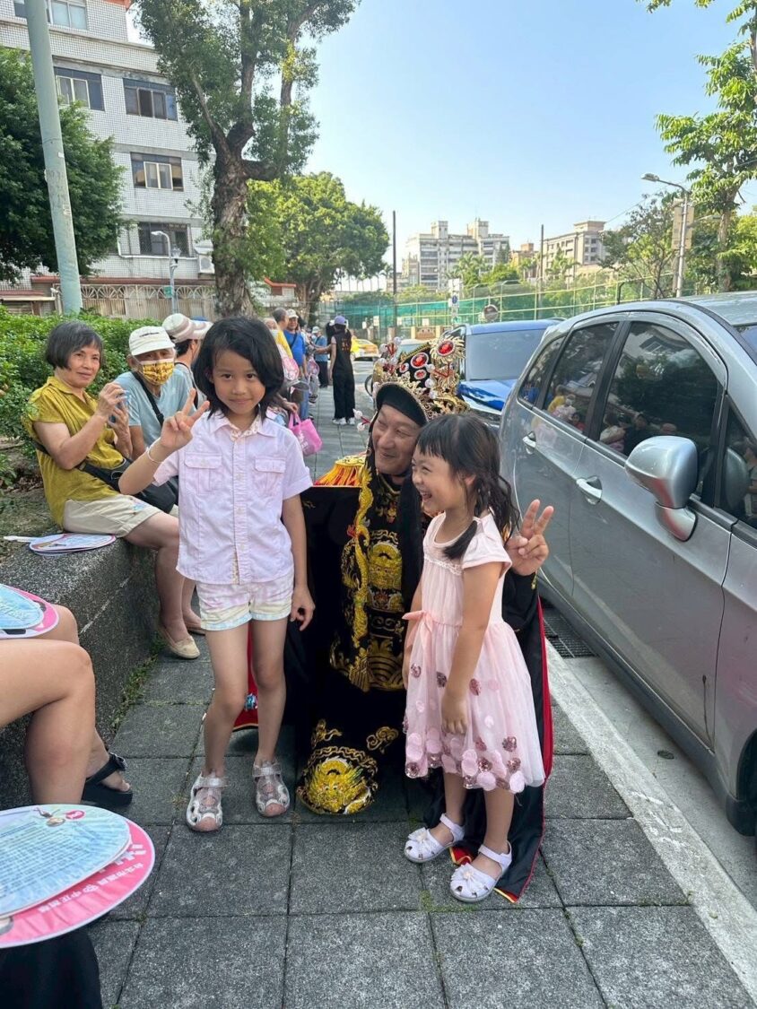 周世雄深入地方與民眾互動，透過川劇變臉公益演出拉近與社區距離，現場小朋友開心合影，氣氛溫馨熱絡。（圖/記者張家燁翻攝）