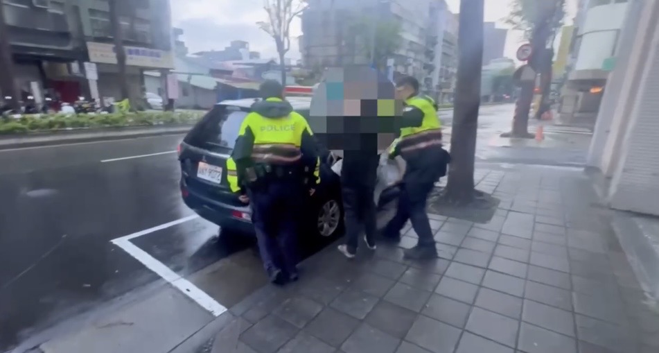 萬華分局員警將犯案男子帶上車。（圖／記者 趙靜姸翻攝）