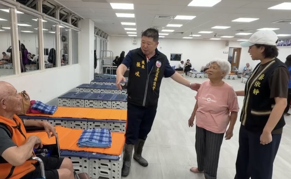 張峻（左二）在避難所關心撤離的居民。（圖／記者 趙靜姸翻攝）