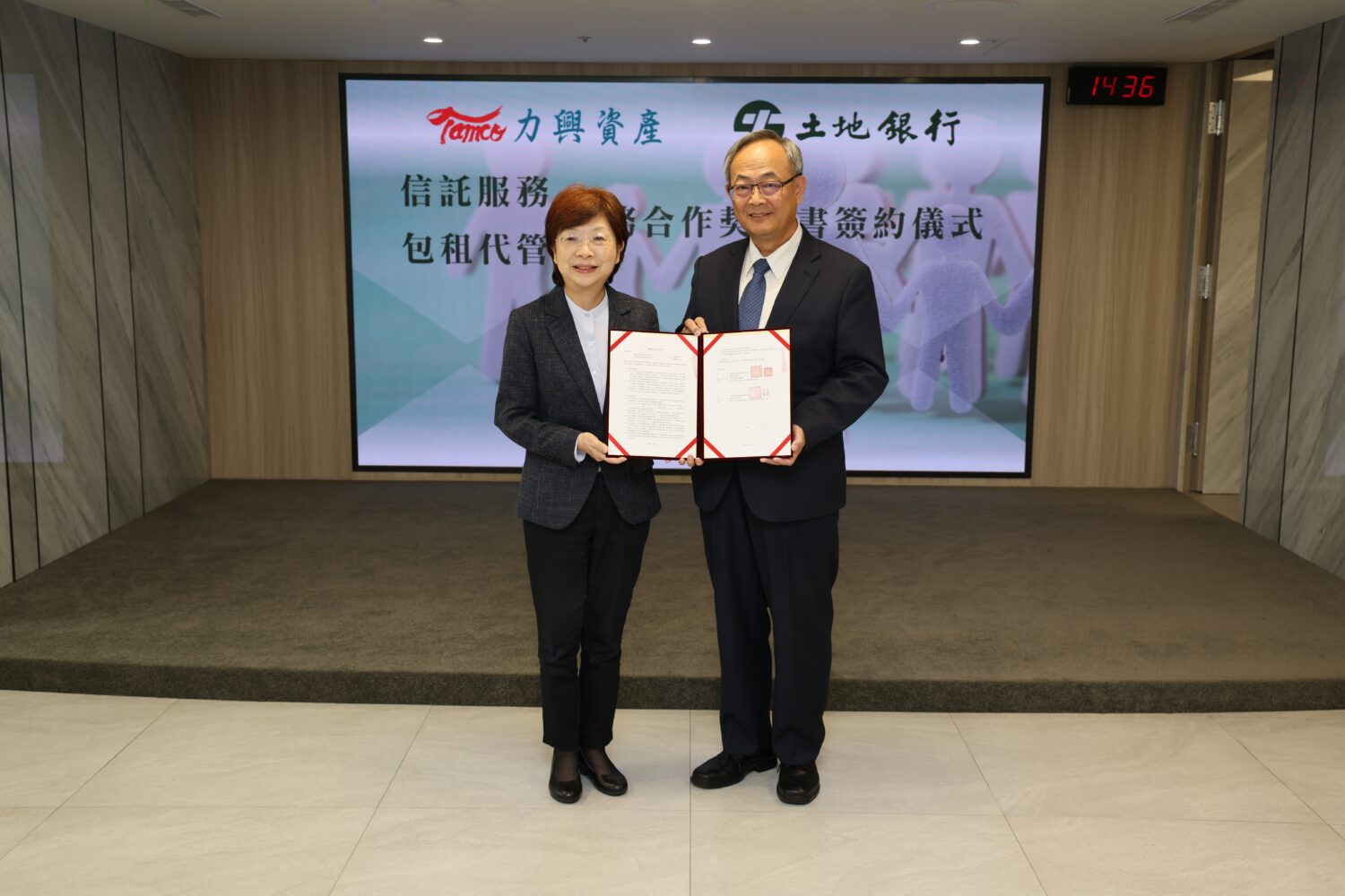 土地銀行與力興資產管理公司舉辦合作包租代管、安養信託跨業結盟模式簽約儀式，土地銀行總經理張志堅（右）、力興資產董事長宮文萍 （左）共同出席。(圖／記者劉其昌 翻攝)