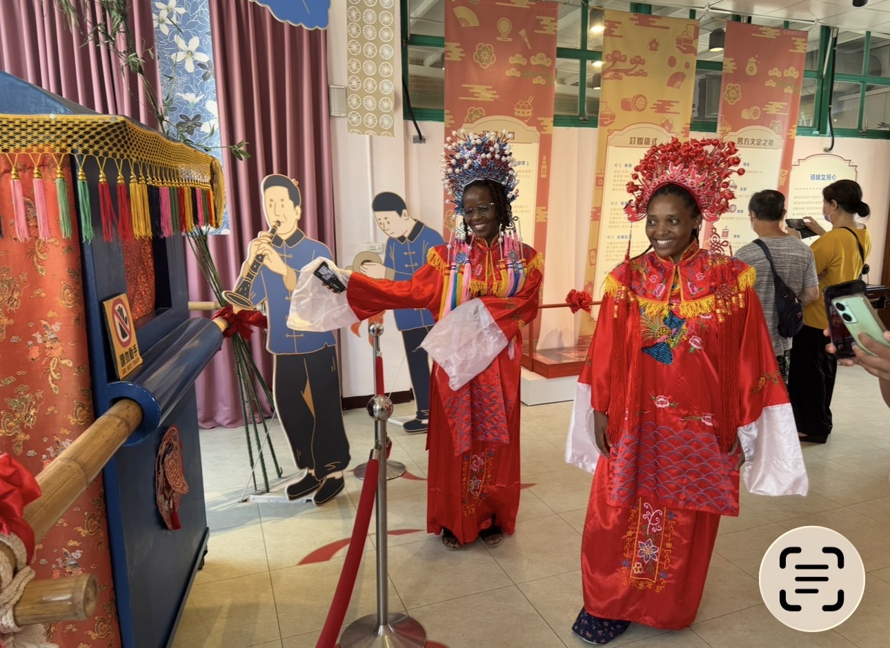 國際友人穿著傳統新娘禮服與鳳冠霞帔,於湖口好客文創園區婚俗文化展示區體驗中華傳統婚禮禮俗,透過互動參與深入認識台灣文化之美。(圖/記者林照東翻攝)
