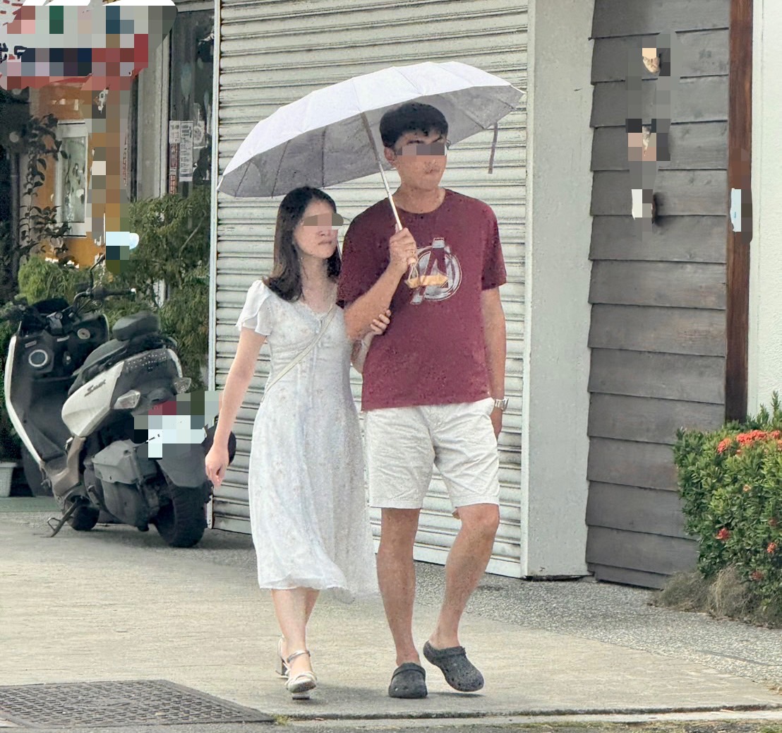 陳姓教師與劉姓女子於外出期間共撐一把傘同行行為親暱。（圖／當事人提供）