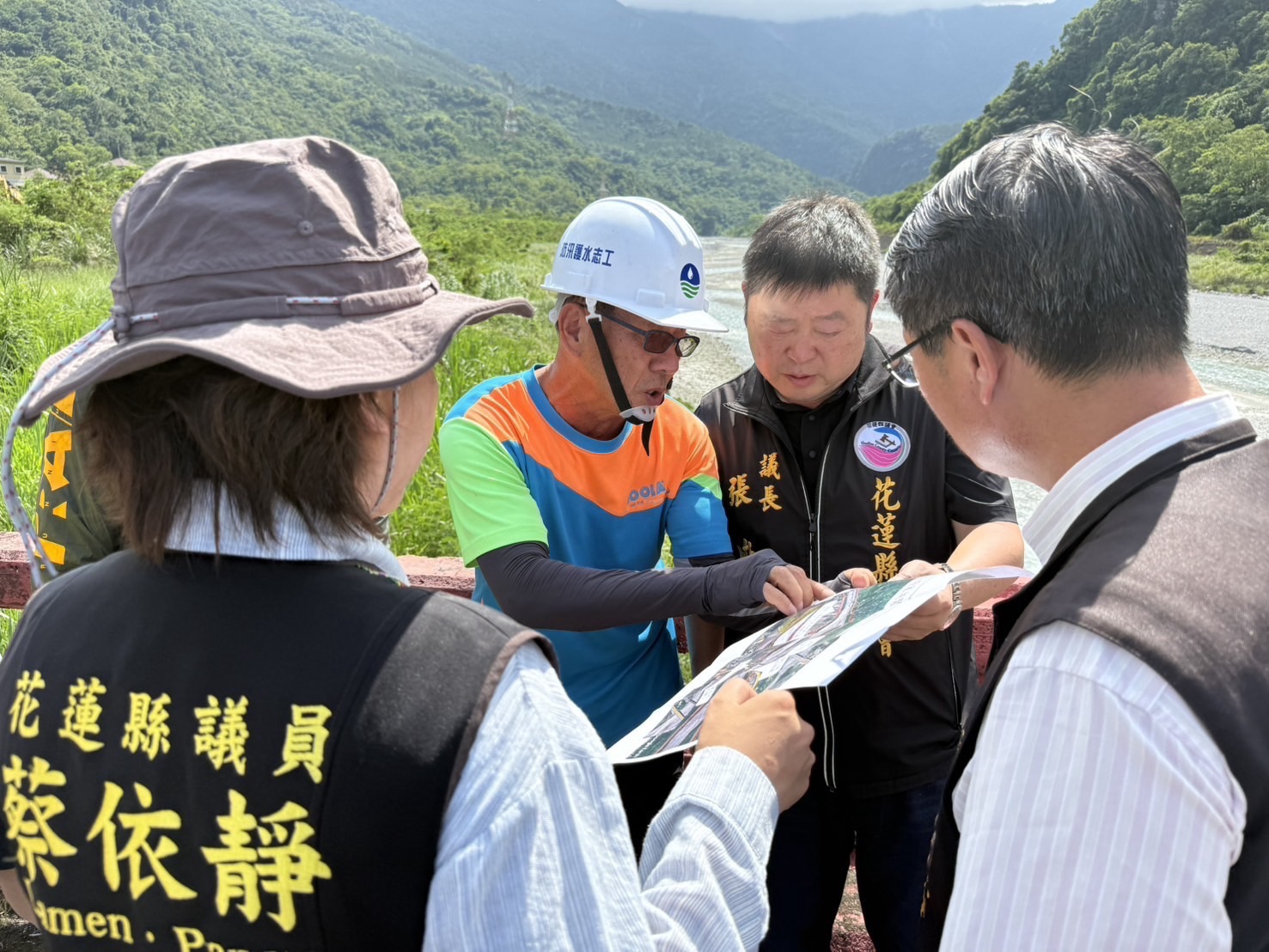 張峻(右二)聽取第九河川分署洪武雄正工程師關於目前萬里溪堰塞湖緊急處置工程規劃內容的說明。(圖/記者 趙靜姸翻攝)