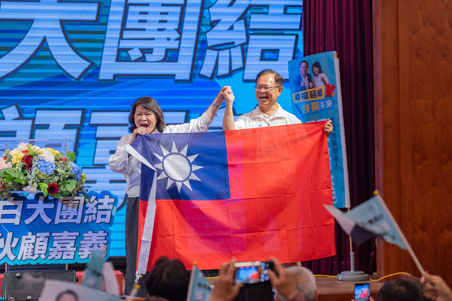 黃敏惠在活動中親自贈送一面大型國旗給張啓楷，象徵市政交棒。(圖／記者翻攝)