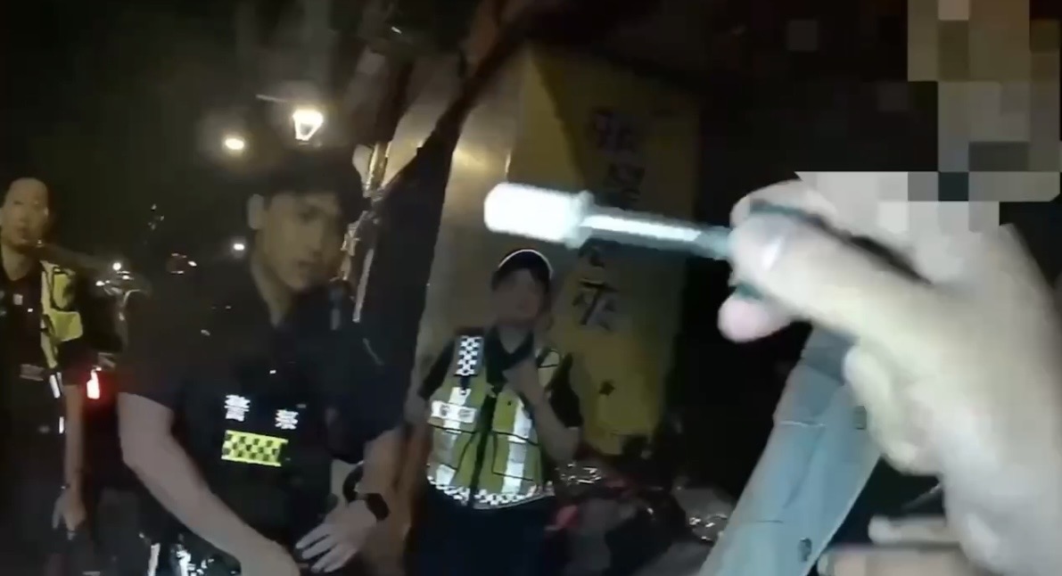 員警對男子實施唾液毒品快篩。(圖/記者 趙靜姸翻攝)